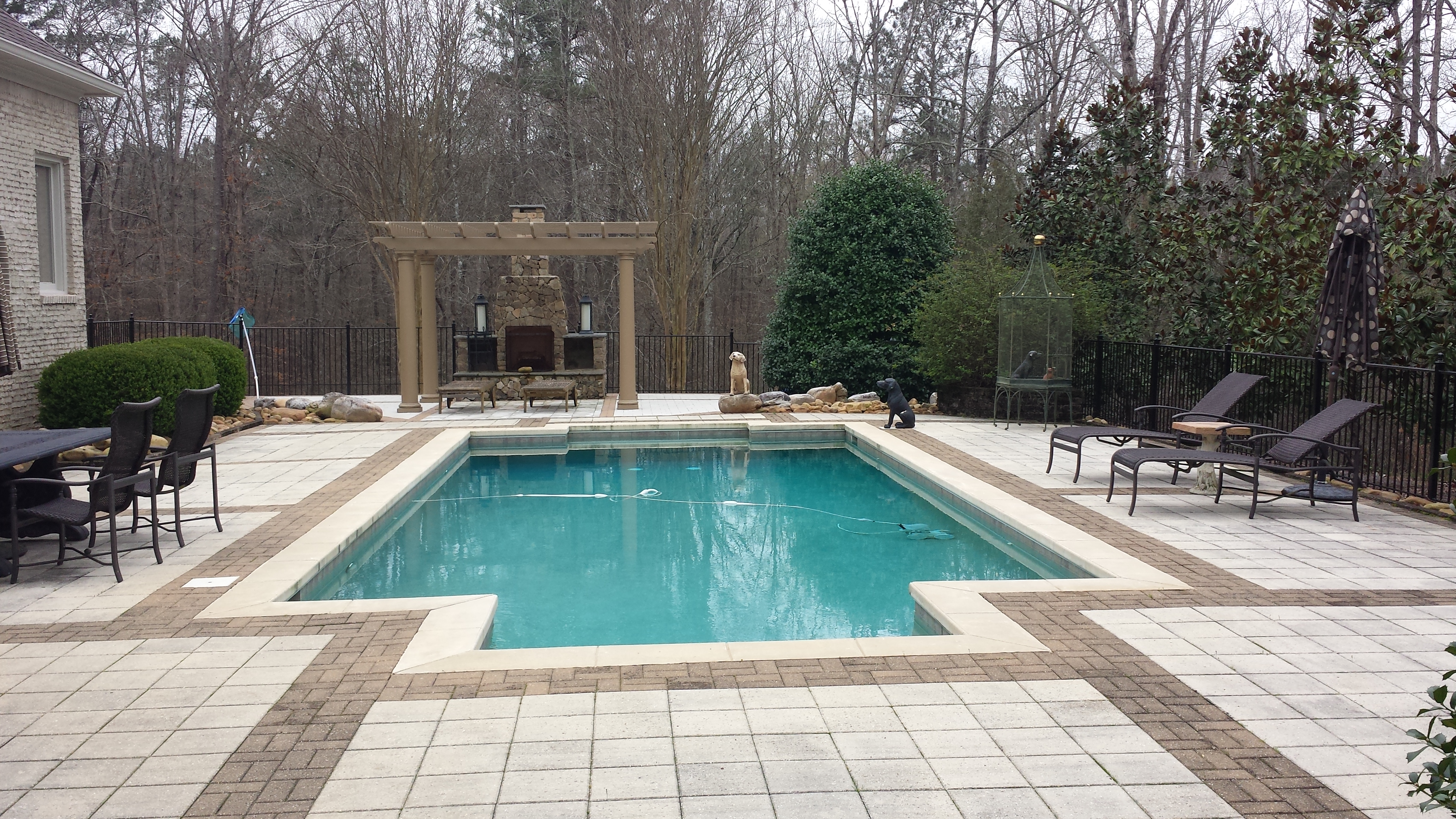 paver pool deck with pergola and stone fireplace